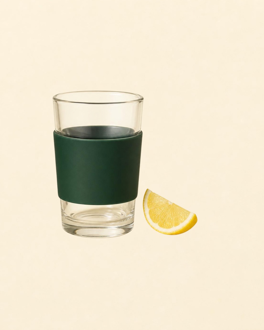 A reusable glass with a forest-green sleeve and a cut lemon wedge